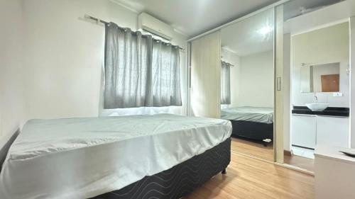 a bedroom with a large bed and a mirror at Casa em Gravatá com piscina privativa por Yolo in Gravatá