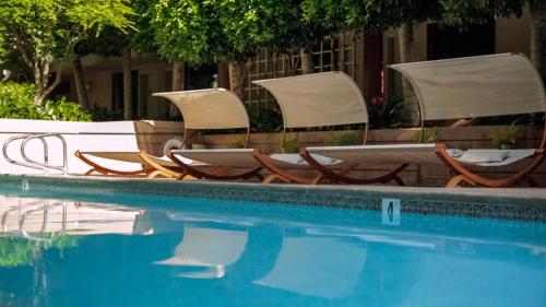 a group of chairs and a swimming pool at Cupertino Hotel in Cupertino