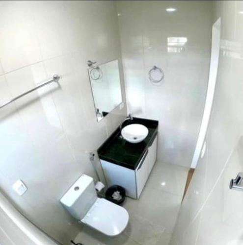 a white bathroom with a toilet and a mirror at Casa em Gravatá com piscina privativa por Yolo in Gravatá