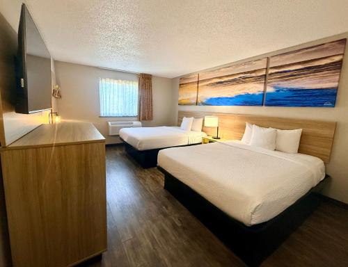 a hotel room with two beds and a television at Days Inn by Wyndham Orange Park/Jacksonville in Orange Park