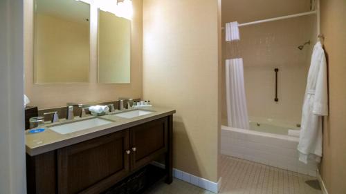 a bathroom with a sink and a shower and a tub at Cupertino Hotel in Cupertino