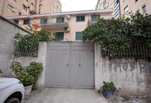a gray garage with a fence and a building at Dedi Apartment 1 in Shkodër