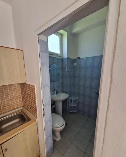 a bathroom with a toilet and a sink at Renato Rooms & Apartments in Vlorë