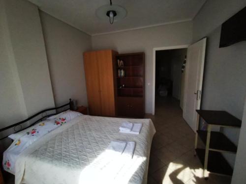 a bedroom with a bed with white sheets and a table at Studio Apartments Eirini in Pyrgi Thermis