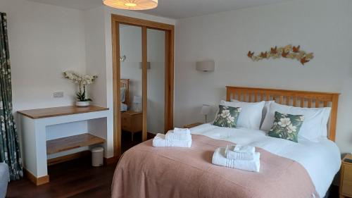 a bedroom with two beds with towels on them at Cottages Lyndale Farm in Flashader