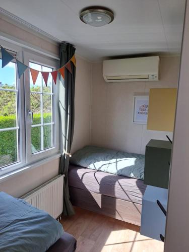 a small room with two beds and a window at ZEEMEEUW - Platz 31, Olmenduin in Serooskerke
