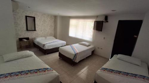 a hotel room with two beds and a television at Hotel Casa Pablo in Neiva