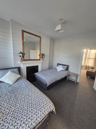 a bedroom with two beds and a mirror at Castle View Dover in Dover