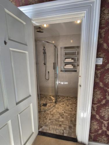a bathroom with a shower with a glass door at Glenduff Manor in Glendiff
