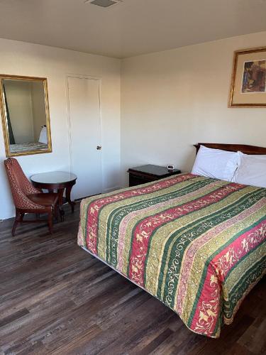 a hotel room with a bed and a table at Crystal Motel in Red Bluff