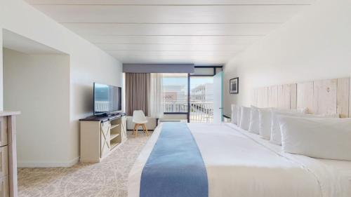 a hotel room with a large bed and a television at The Forum in Ocean City