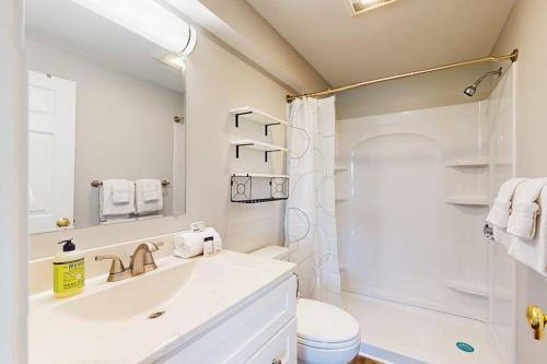 a white bathroom with a sink and a shower at Splash & Relax Unit 203 in Wells