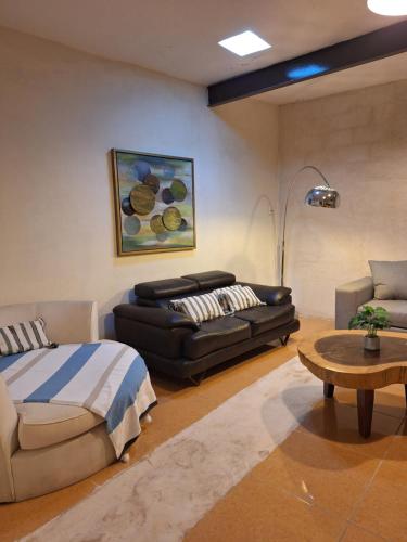 a living room with a bed and a couch at Santuario del Sol in Mérida