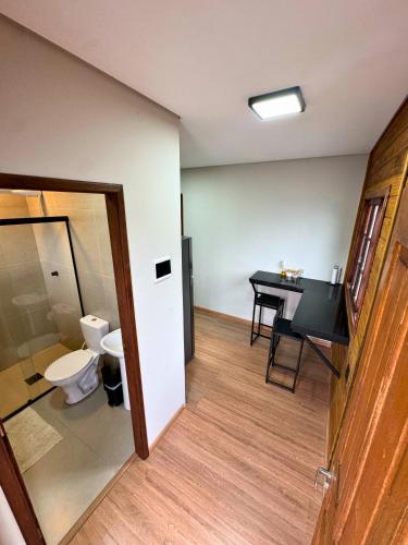 a bathroom with a toilet and a table and a desk at Pousada Barcelos Florianópolis in Florianópolis