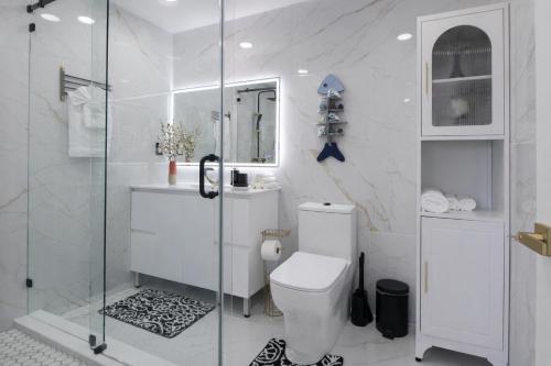 a bathroom with a toilet and a glass shower at Ebenezer Home in Hallandale Beach