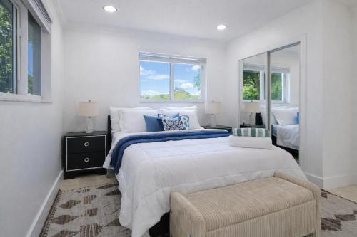 a bedroom with a bed and a chair and windows at Ebenezer Home in Hallandale Beach