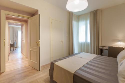 a hotel room with a bed and a hallway at Hotel Atlantico in Forte dei Marmi