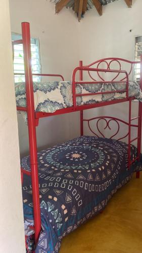two red bunk beds in a room with a bed at las casitas acogedora in Las Galeras