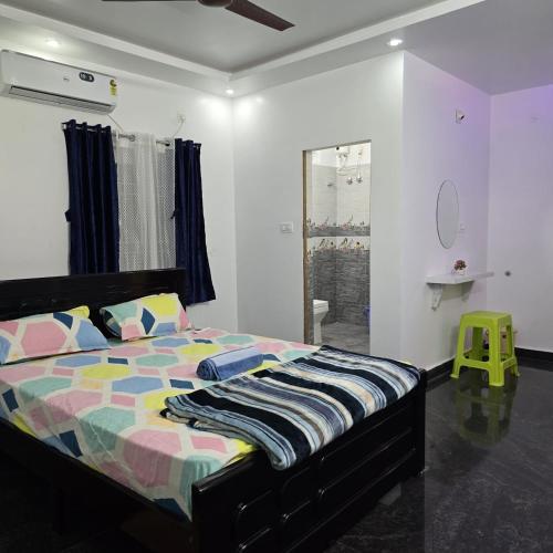 a bedroom with a bed with a colorful comforter at Padmini's home stay New apartment 2bhk in Tirupati