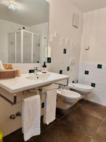 a white bathroom with a sink and a toilet at Maso Sasso - La Locanda di Putipù in Villa Lagarina
