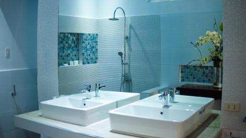 a bathroom with two sinks and a mirror at Lio Villas Resort in El Nido