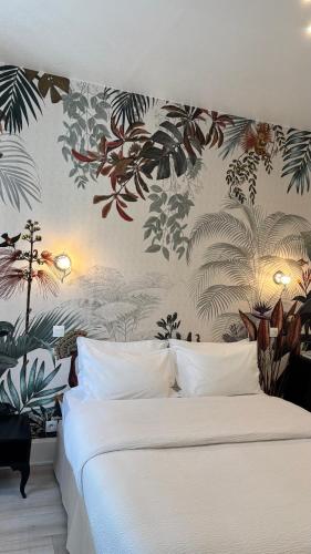 a bedroom with a white bed with a floral wallpaper at Logis Hôtel Restaurant Grand Hôtel de Lyon in Vals-les-Bains