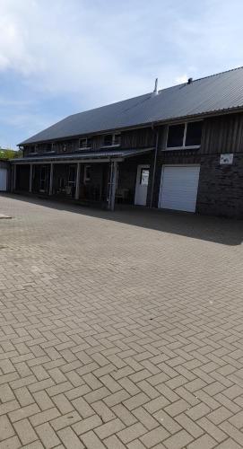 a building with two garage doors and a brick driveway at Franzenhof Beldorf in Beldorf