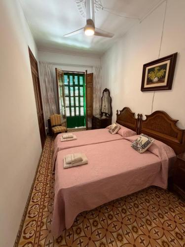 a bedroom with a large bed with a pink blanket at Ca'n Claret in Llucmajor
