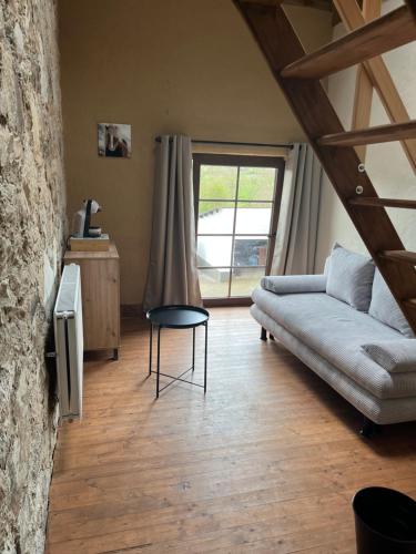 a living room with a couch and a table at Aux Sabots du Temps in Vielsalm