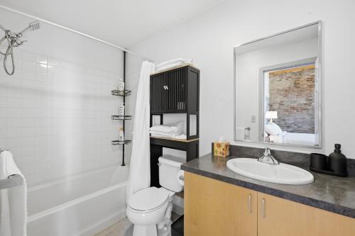 a bathroom with a white toilet and a sink at Gorgeous downtown apartment with loft in Hartford