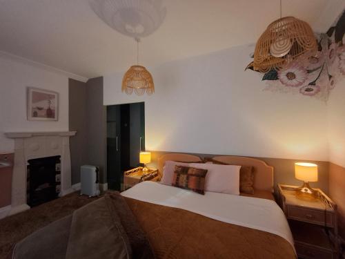 a bedroom with a bed with two lamps and a fireplace at Jesmond B&B Kingsize Ensuite Room 2 in Hull