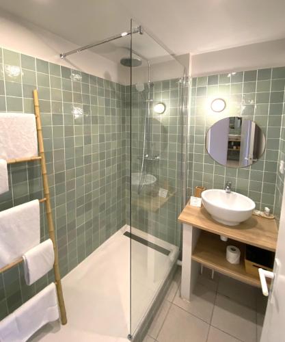 a bathroom with a sink and a glass shower at Hôtel Bellevue Cap d'Agde in Cap d'Agde