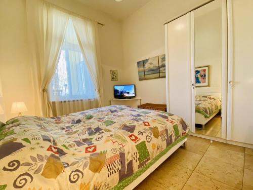 a bedroom with a bed and a mirror and a television at Villa Caprivi 1 in Heringsdorf