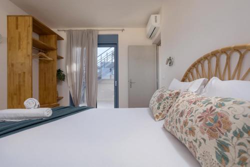 a bedroom with a white bed with a wooden headboard at Antimo Villas - Gallini Beach House in Zakynthos