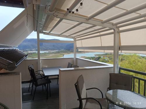 a balcony with a table and chairs and a view at Apartmani Venecia in Prozor
