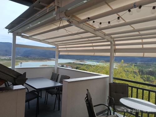 a table and chairs on a balcony with a view at Apartmani Venecia in Prozor