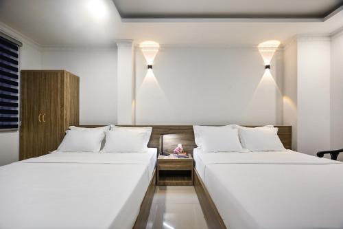 two beds sitting next to each other in a room at Trung Mai Sân Bay T3 in Ho Chi Minh City