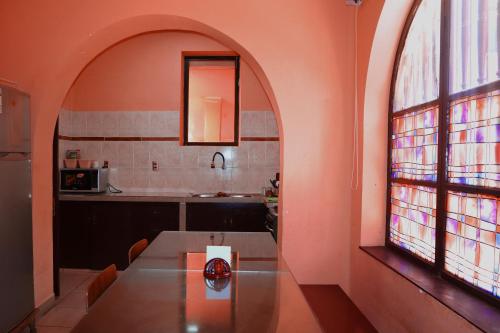 a kitchen with an arched window and a wooden table at Casa Tréveris in Sucre