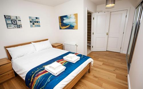 a bedroom with a bed with two towels on it at Waterfront- London Greenwich o2 Arena 2 Bed Flat in London
