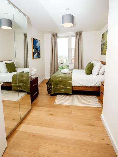 a bedroom with two beds and a mirror at Waterfront- London Greenwich o2 Arena 2 Bed Flat in London