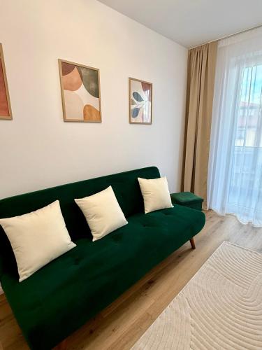 a green couch sitting in a living room at Emerald Stay in Şelimbăr