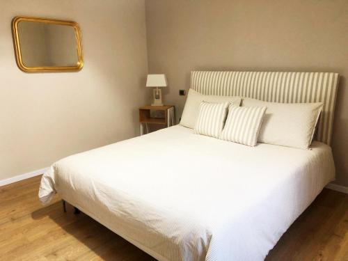 ein Schlafzimmer mit einem weißen Bett und einem Spiegel an der Wand in der Unterkunft Da Magy in Arborea 
