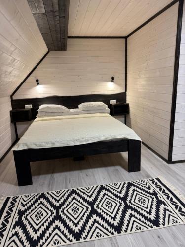 a bedroom with a bed and a rug at Садиба У Ані номер 7 in Synevyrsʼka Polyana
