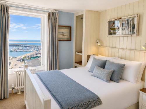 a bedroom with a large bed and a large window at The Royal Harbour Hotel in Ramsgate