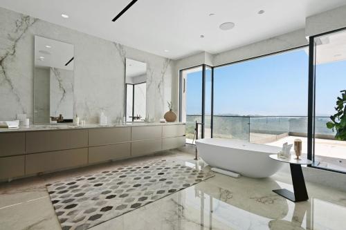 a bathroom with a tub and a large window at Stradella Como in Beverly Glen