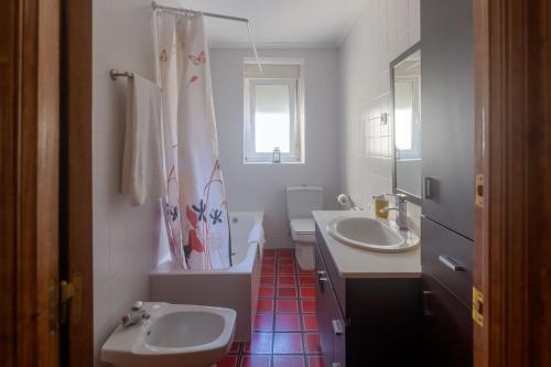 a bathroom with two sinks and a tub and a toilet at Casa Salamó in Ampuero