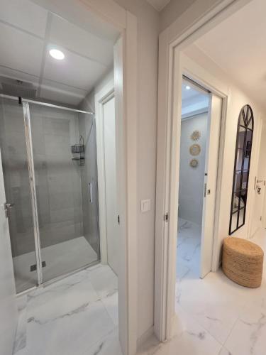 a bathroom with a walk in shower and a glass door at Flamenca Village Apartment SALSA in Orihuela Costa