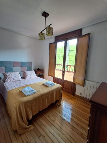 a bedroom with a bed and a large window at Casa Salamó in Ampuero