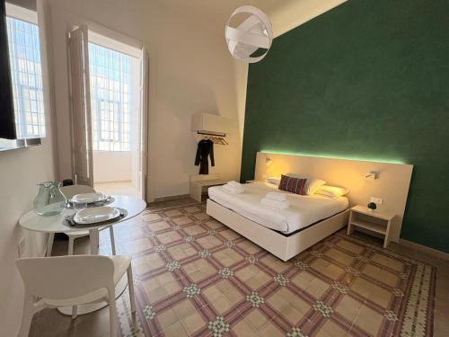 a bedroom with a bed and a green wall at Casa Blanca Rooms&Suites in Reggio di Calabria