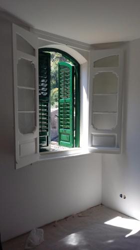 an open window in a room with a green door at Parva Domus Intera casa indipendente in centro in Modica
